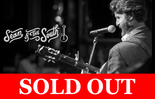 Black-and-white promotional image of Sean of the South performing with a guitar at a microphone, with ‘SOLD OUT’ banner across the bottom.